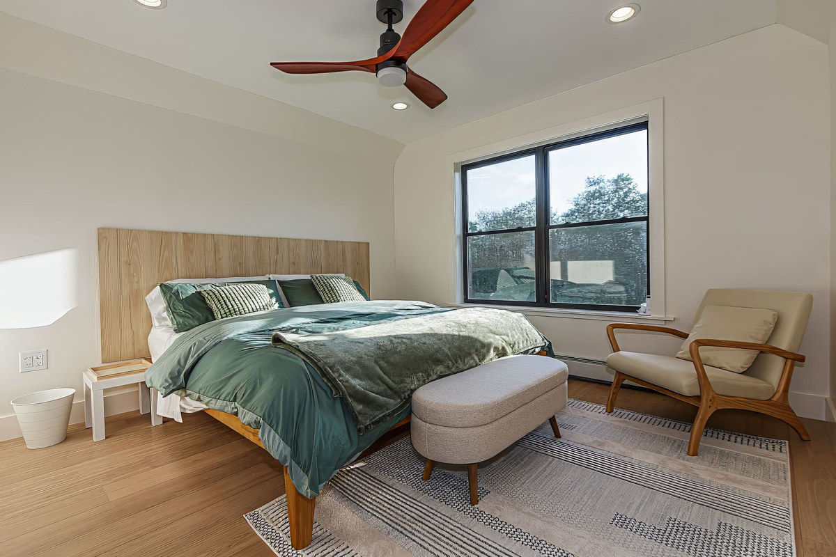 Bright bedroom with green bedding and reading chair