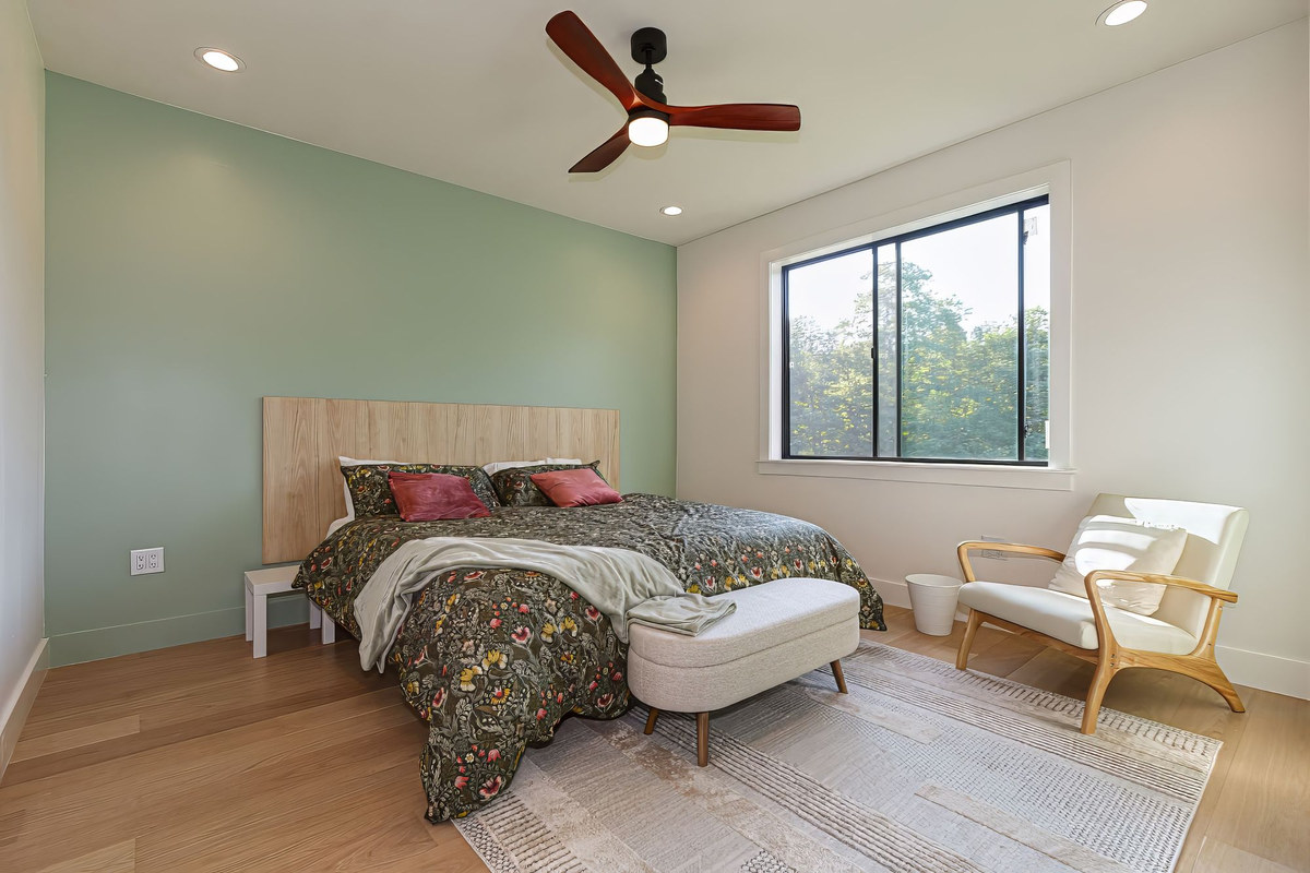 Bedroom with sage accent wall and reading chair