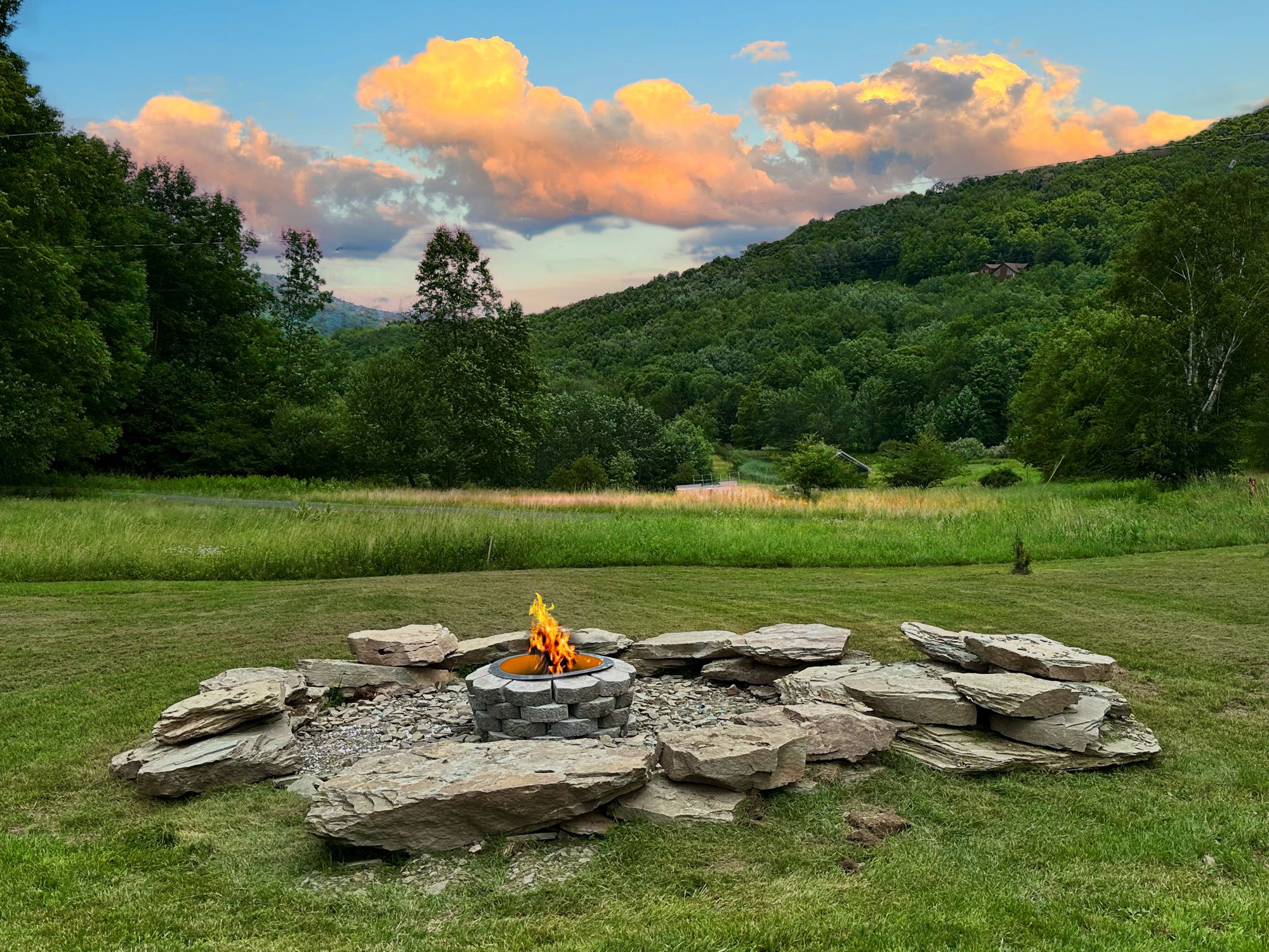 Stone fire ring on the lawn at sunset