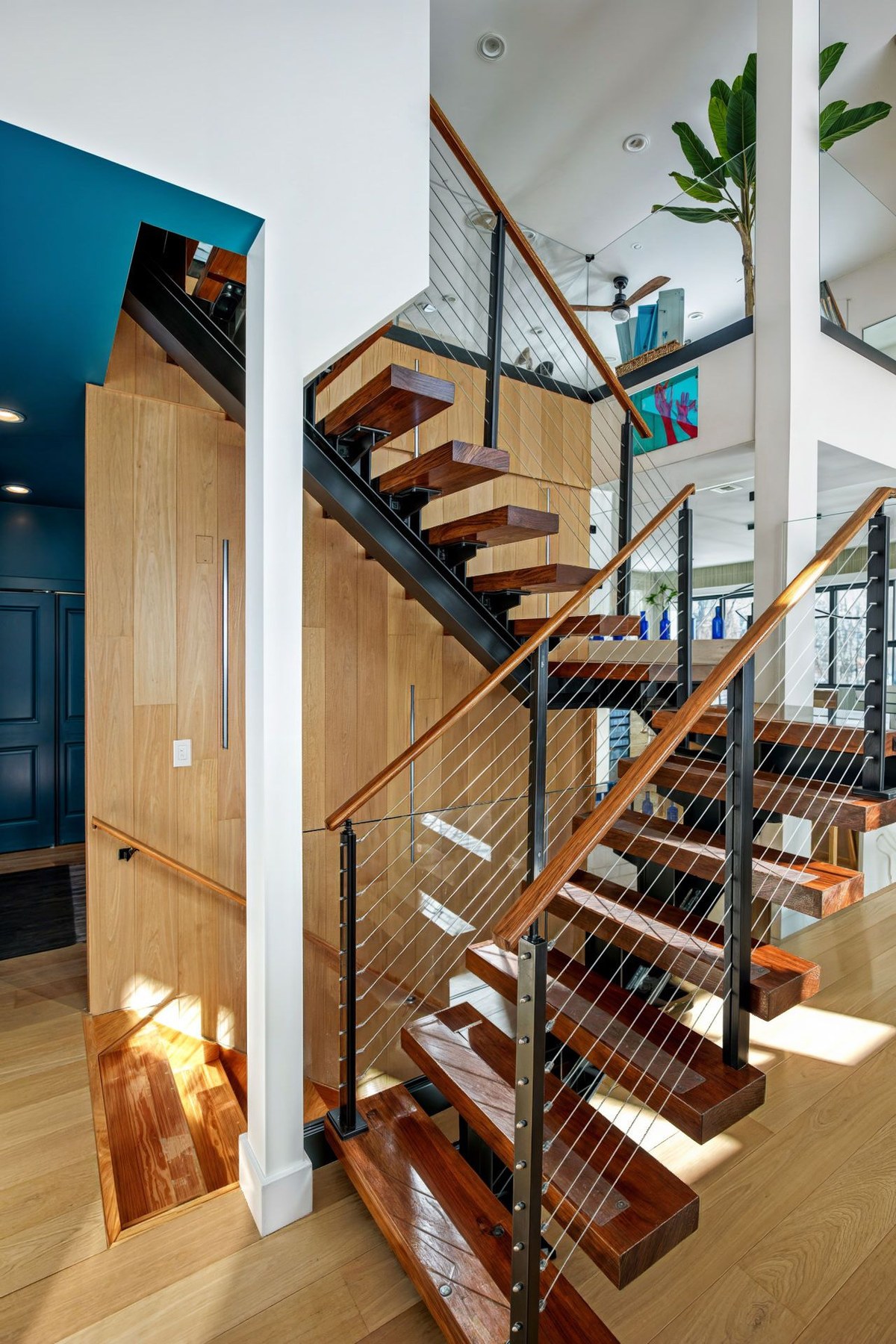Floating wood-and-steel staircase with cable railing