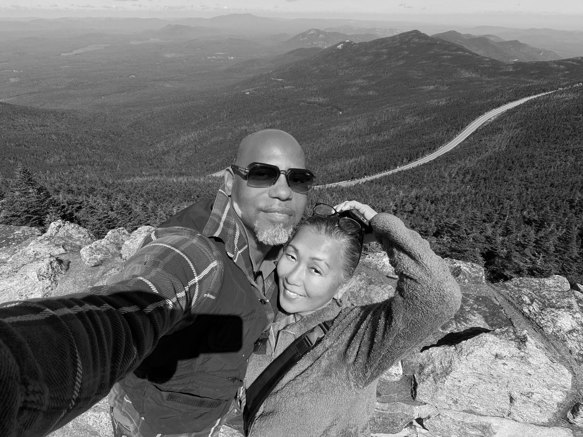 Dmitri and Lea, SOL’s hosts, cheek to cheek on a rocky summit above a wide forested valley